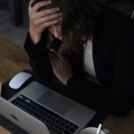 شخص يشعر بالتعب والإرهاق أثناء الجلوس إلى المكتب.